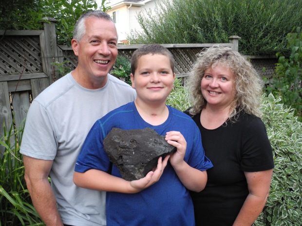 Kyle Frappier with his parents and a volcanic rock